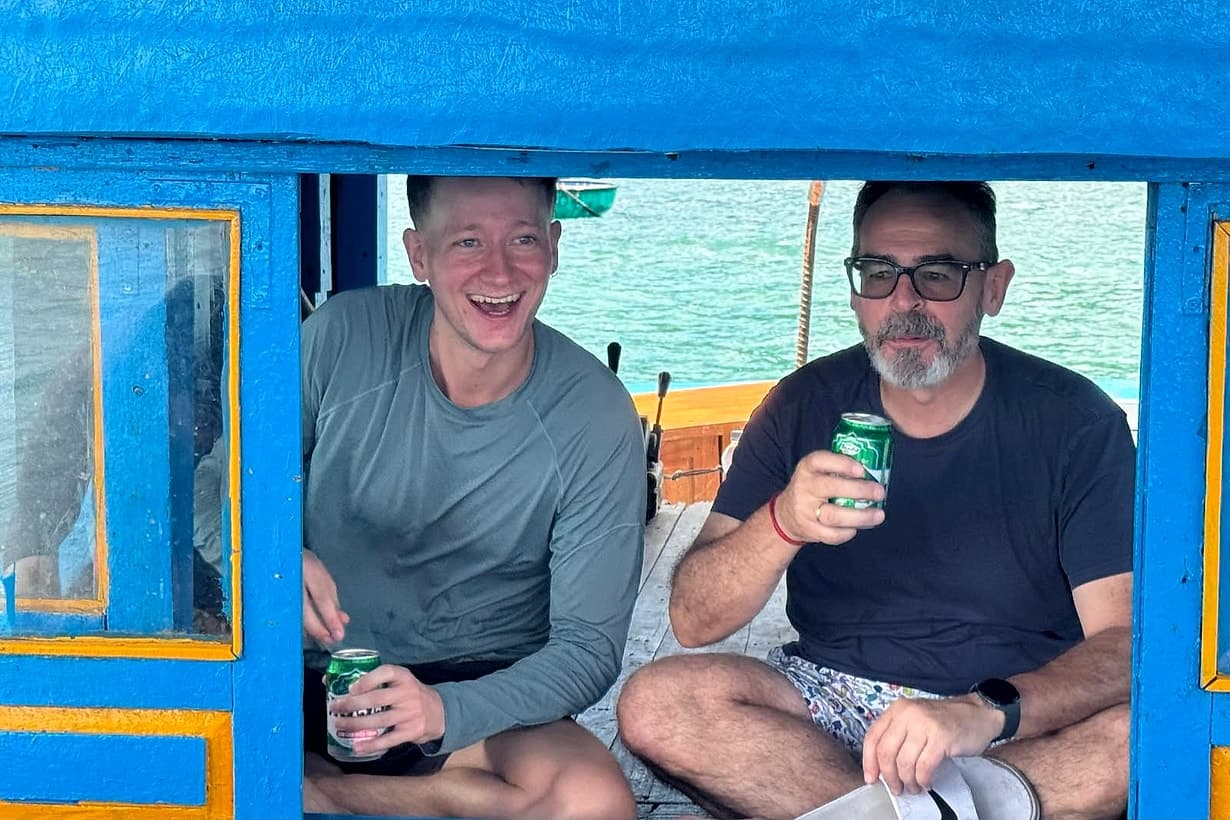 Two friends sharing a beer on a boat day in Da Nang